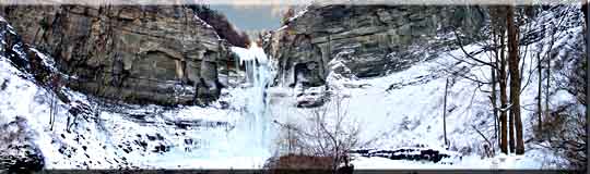 A panoroma photograph of Taughannock Falls frozen in winter.