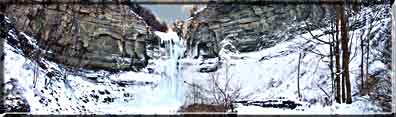 A Panoramic photograph showing Taughannock Falls in winter ice.