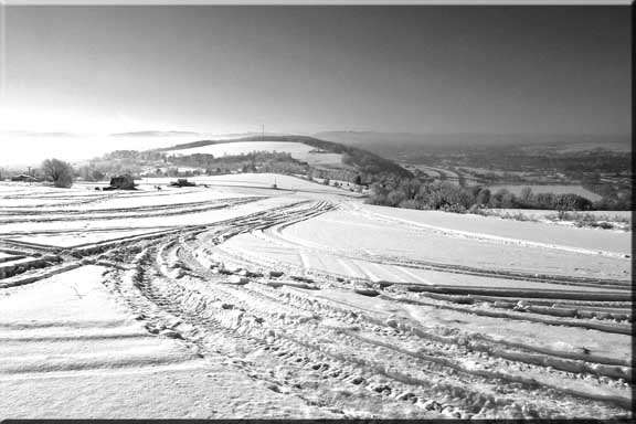 Tracks in the snow leading one's eye to the distant ice-misted hills.