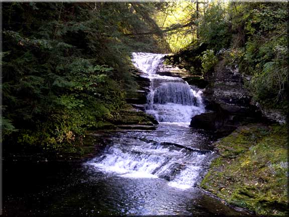A multiple cascade tumbling from a sunlit crevice.